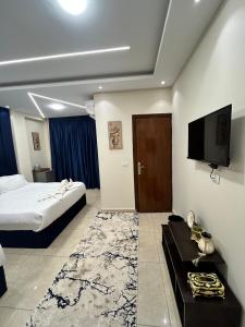 a hotel room with a bed and a flat screen tv at Casa pyramids hotel in Cairo