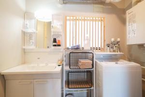 a small kitchen with a sink and a washing machine at plus81 OTARU Entire House 9min Walk from Minami Otaru Station in Otaru +54 photos