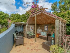 a wooden gazebo with a couch and chairs at Inn-Style in Cape Town