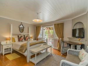a bedroom with a bed and a tv and a couch at Inn-Style in Cape Town