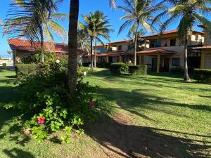 a house with palm trees and flowers in the yard at Resort felicidade in Extremóz