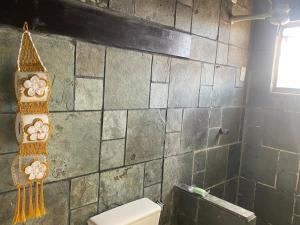 a bathroom with a toilet and a tiled wall at Resort felicidade in Extremóz +7 photos