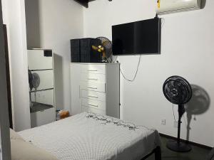 a bedroom with a bed and a tv and a fan at Resort felicidade in Extremóz