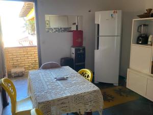 a kitchen with a table with chairs and a refrigerator at Resort felicidade in Extremóz