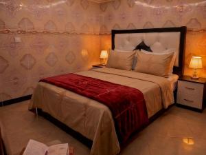 a bedroom with a large bed with a red blanket at Aziz House 2 Tan Tan in Tan-Tan