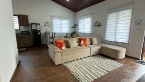 a living room with a couch and a kitchen at Cozy Calm Refuge in Alto Boquete