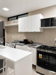 a kitchen with white cabinets and a stove top oven at Life Center in Caruaru
