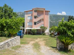 a building with a car parked in front of it at Apartments Music in Sutomore