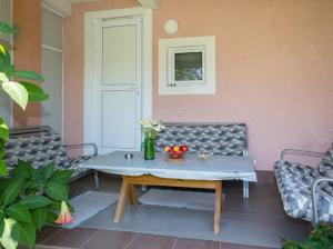 a patio with a table and a bench and flowers at Apartments Music in Sutomore