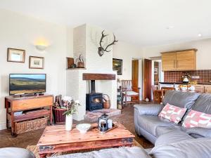a living room with a couch and a fireplace at Beehive Cottage Culbone in Porlock
