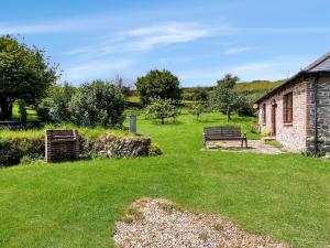 a yard with two benches and a building at Beehive Cottage Culbone in Porlock +11 photos