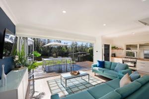 a living room with a blue couch and a table at The River Retreat in Sussex Inlet