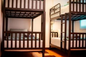 a room with two bunk beds and a mirror at Honey You HOSTEL in Ban Khlong Mat