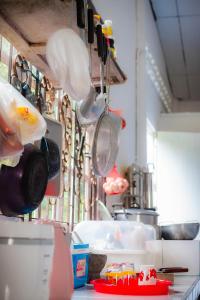 a kitchen with many pots and pans and utensils at Honey You HOSTEL in Ban Khlong Mat +15 photos