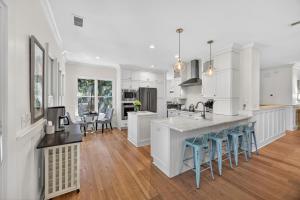a kitchen with white cabinets and blue bar stools at OG14: 14 Ocean Green in Kiawah Island