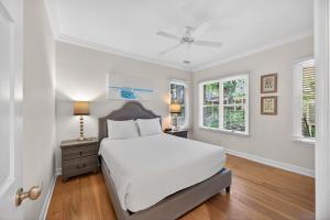 a white bedroom with a bed and two windows at OG14: 14 Ocean Green in Kiawah Island +34 photos