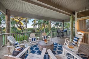 a porch with rocking chairs and a table at SS3512: 3512 Seascape in Kiawah Island