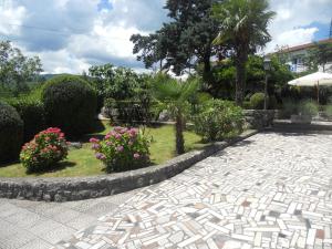 a garden with flowers and plants on a sidewalk at Apartment Milano in Matulji