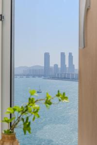 a window with a view of the water and a city at 광안리 써니 스테이 #무료주차 in Kwangan-dong