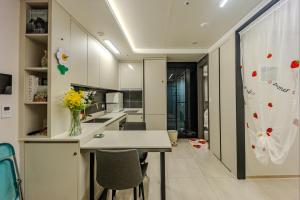 a kitchen with white cabinets and a table and chairs at 광안리 써니 스테이 #무료주차 in Kwangan-dong