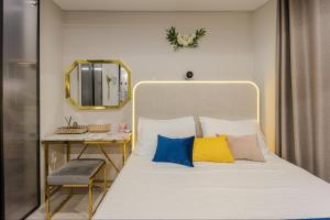 a bedroom with a bed with colorful pillows and a mirror at 광안리 써니 스테이 #무료주차 in Kwangan-dong