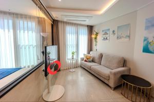 a living room with a couch and a bed at 광안리 써니 스테이 #무료주차 in Kwangan-dong