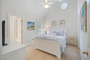 a white bedroom with a bed and a ceiling fan at OG23: 23 Ocean Green in Kiawah Island +42 photos