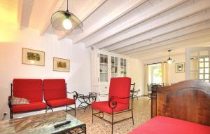 a living room with red chairs and a table at Authentique Villa Piscine in Taulis