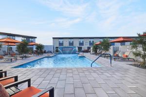 a pool at a hotel with tables and chairs at Sonoran Oasis with Pool, Spa & BBQ Area in Phoenix