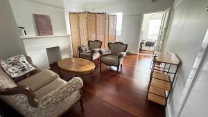 a living room with a couch and chairs and a table at Main road apartment in Sydney +9 photos