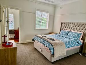 a bedroom with a bed with a blue comforter at Main road apartment in Sydney