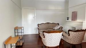 a living room with two chairs and a table at Main road apartment in Sydney