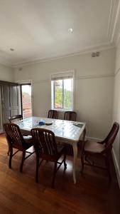 a dining room with a table and four chairs at Main road apartment in Sydney