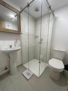 a bathroom with a shower and a toilet and a sink at Hotel Medallo City in Medellín