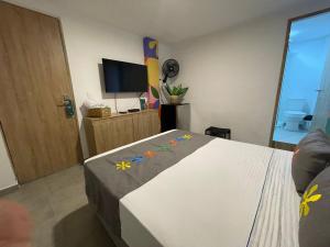 a bedroom with a bed and a flat screen tv at Hotel Medallo City in Medellín
