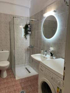 a bathroom with a sink and a washing machine at KallitheaDeluxe in Kallithea Halkidikis