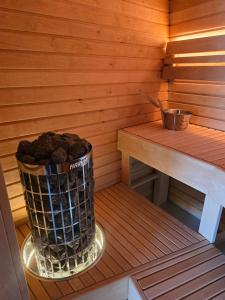 a sauna with a trash can next to a bench at Mullimaja in Treimani