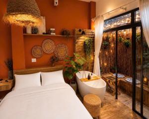 a bedroom with a bath tub and a bed and a tub at LàMin Homestay in Ấp Long Ðại