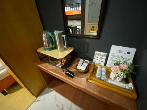 a dressing table with a mirror and flowers on it at Angkel's Place in Bangued