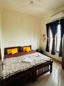 a bedroom with a large bed with orange pillows at VVR villa in Tirupporūr