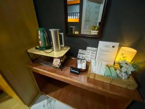 a wooden table with a shelf with books and a mirror at Angkel's Place in Bangued