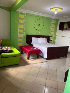 a bedroom with a bed and a bench and a clock at Hôtels Bali in Yaoundé