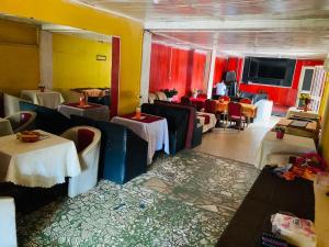 a restaurant with tables and chairs and red walls at Hôtels Bali in Yaoundé