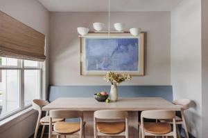 a dining room table with chairs and a vase with flowers at Modern Designer Home with Shared Pool in Austin