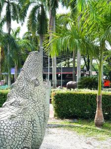 a large statue of a bear in front of palm trees at Hotel Porton De Oriente in Puerto Triunfo +22 photos