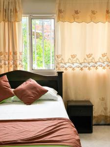 a bedroom with a bed and a window with curtains at Hotel Porton De Oriente in Puerto Triunfo