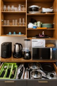 a kitchen with a stove with a microwave and utensils at Roupa cama Wi-Fi garagem ar Cond beira mar 50 m in Tramandaí