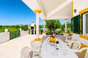 a patio with a white table and white chairs at Villa Sol Nascente in Porches