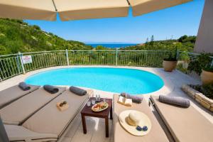 a patio with a pool and a table and chairs at Villa Elpida in Gaios