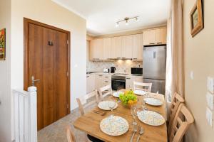 a kitchen with a wooden table with plates of food on it at Villa Elpida in Gaios